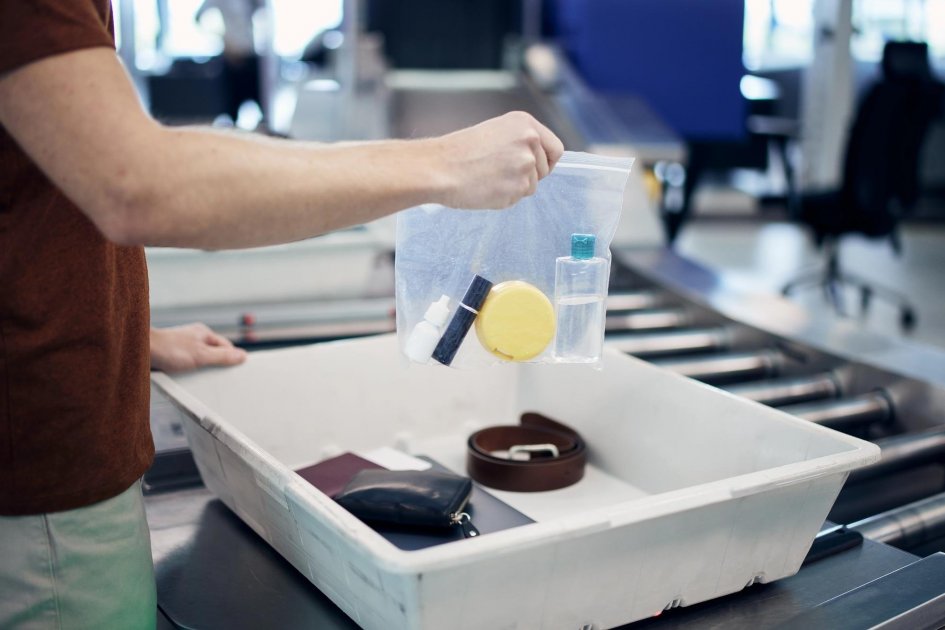 A passenger is holding a clear bag containing liquids at security