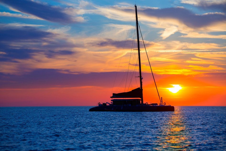 Sunset in San Antonio from a catamaran, with the sun in the background