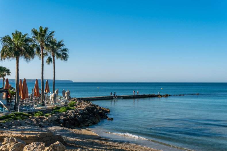 General view of Can Pere Antoni beach with the city of Palma de Mallorca на тлі сходу сонця.