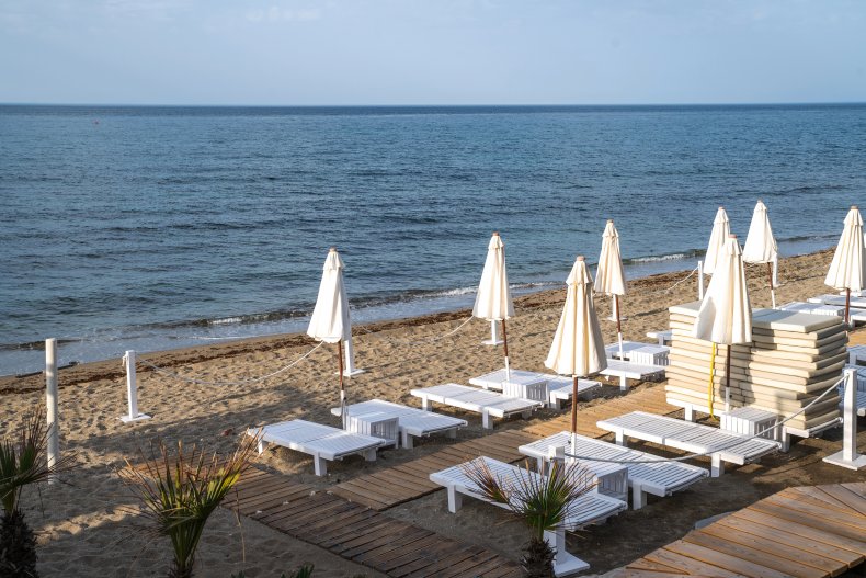 Beach resort, sea summer vacation concept. Lounge wooden sunbeds with umbrellas. A row of sunbeds at a beach resort.