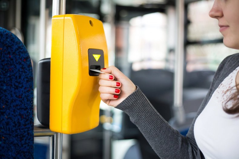 Una mano introduce el billete en el validador del transporte público