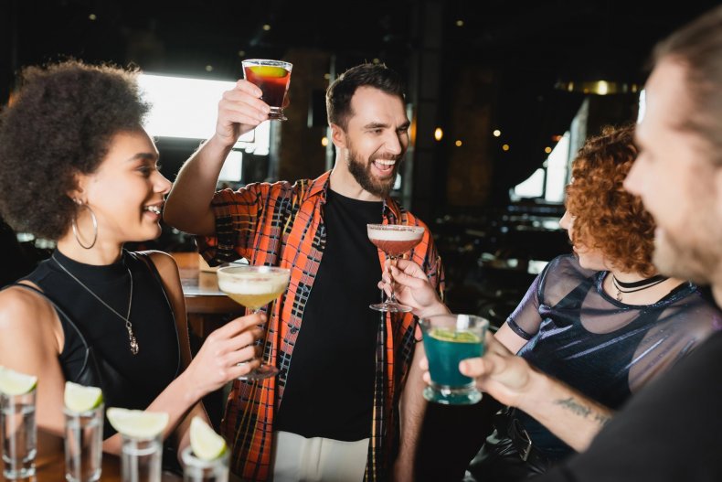 A group of friends enjoying cocktails at a bar in the evening