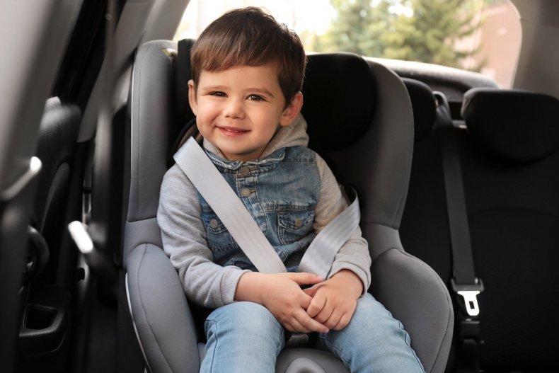 Un niño en una silla infantil de seguridad en el asiento trasero
