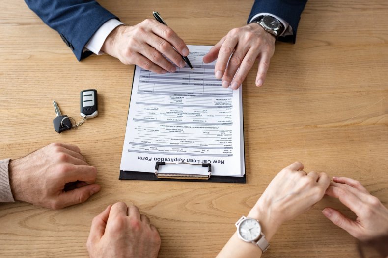 El concesionario firma el contrato con los clientes en la oficina