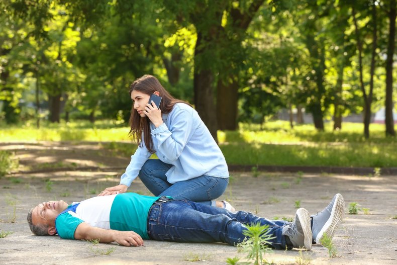 Una mujer llama por teléfono a una ambulancia desde la calle