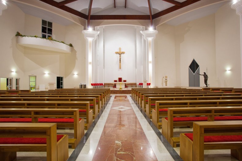 Interior moderno de una iglesia con filas de bancos y bóvedas claras