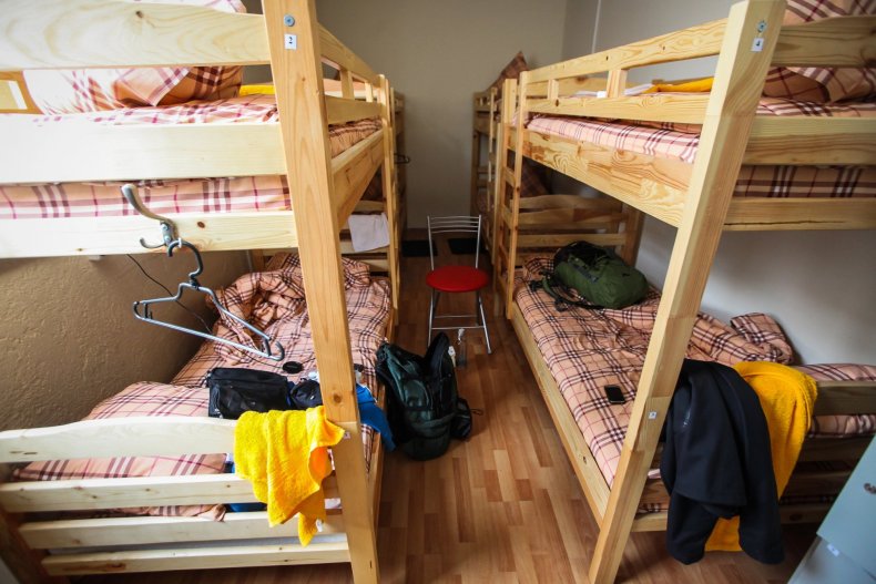 The interior of a budget hostel with bunk beds and travelers' backpacks