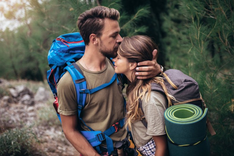 A young couple hiking in the mountains — an active outdoor adventure
