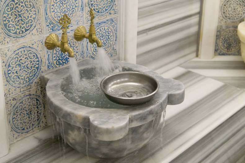 Marble fountain and blue tiles of a traditional Turkish hammam