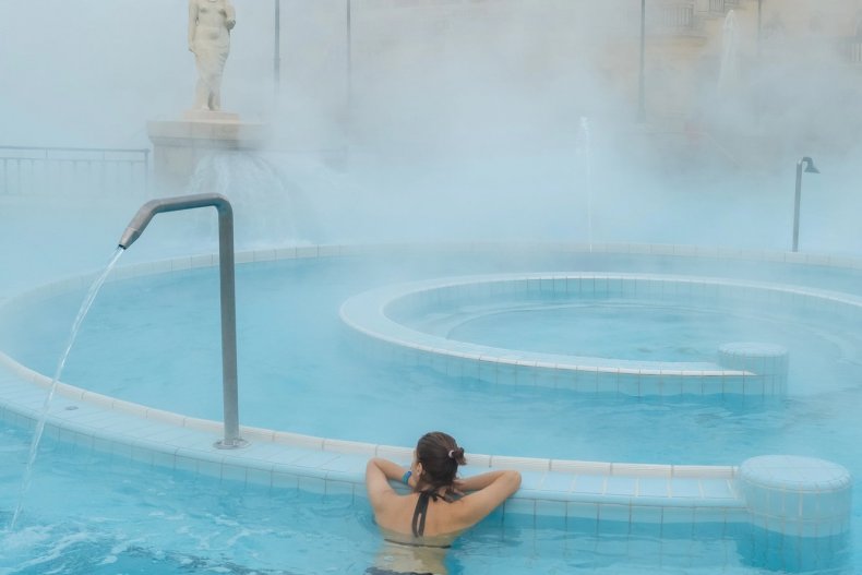 Woman relaxing in a warm outdoor thermal pool in winter