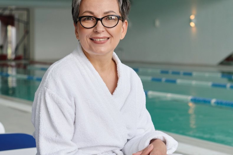 Woman in a robe resting on a lounge chair at a spa