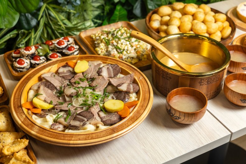 Table with traditional Kazakh dishes — beshbarmak with boiled meat