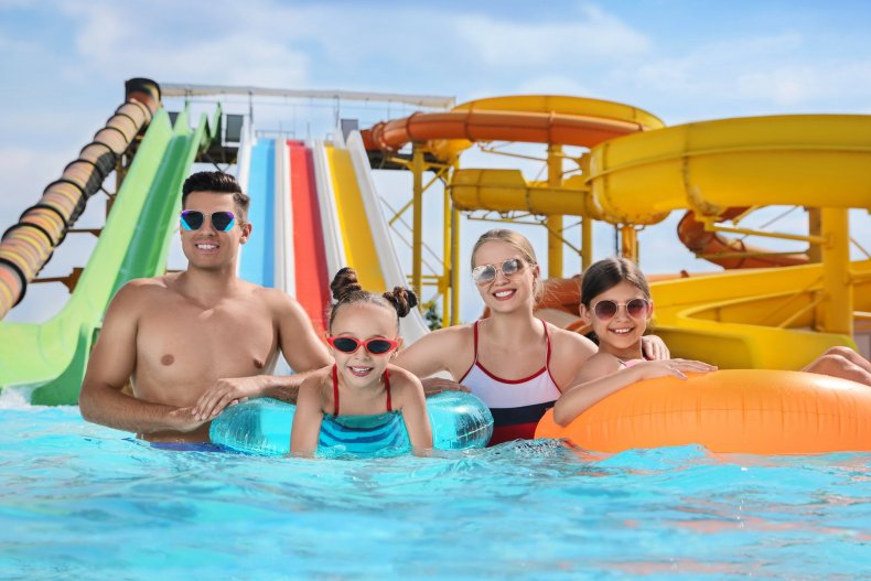 A happy family with inflatable rings in a water park pool
