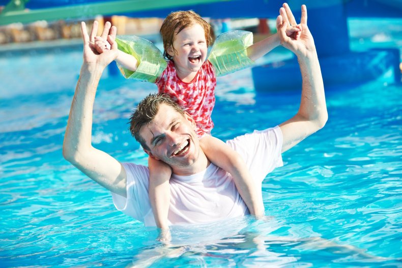 Un padre con su hijo en la piscina de un hotel de vacaciones